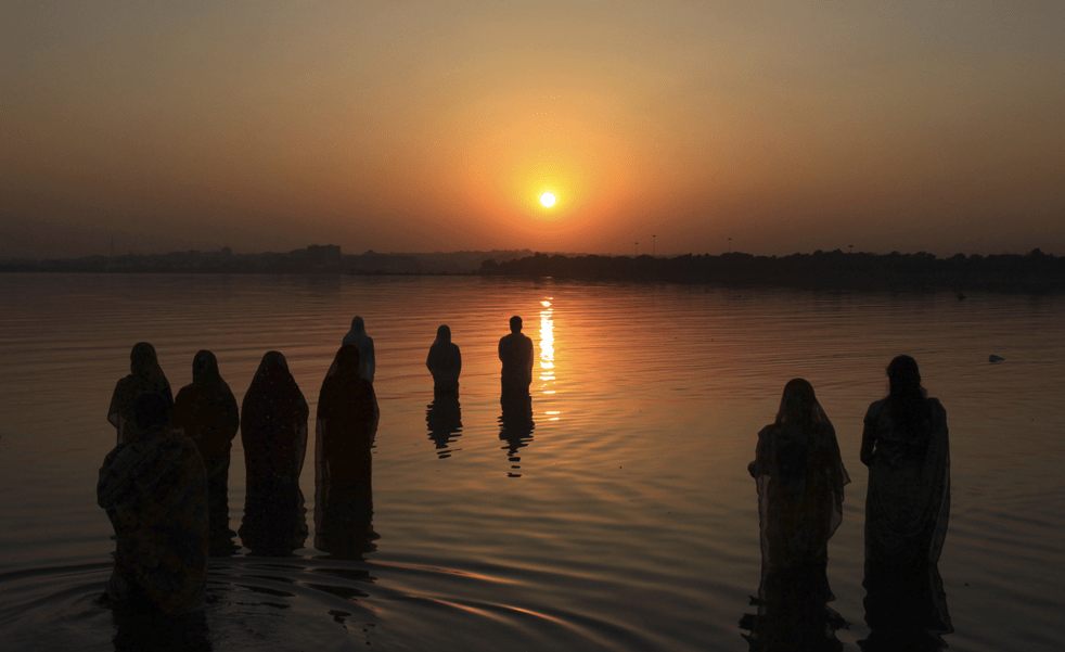 Traditional Chhath Puja prayers performed by women standing in sacred waters