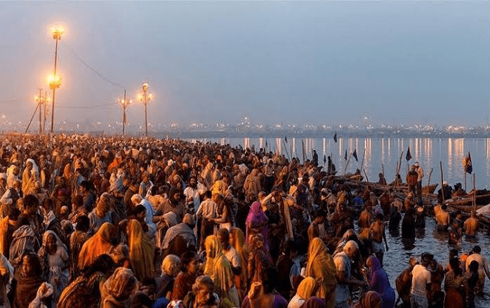 Devotees offering arghya to Surya at river ghat during Chhath Puja, symbolizing sun worship and renewal